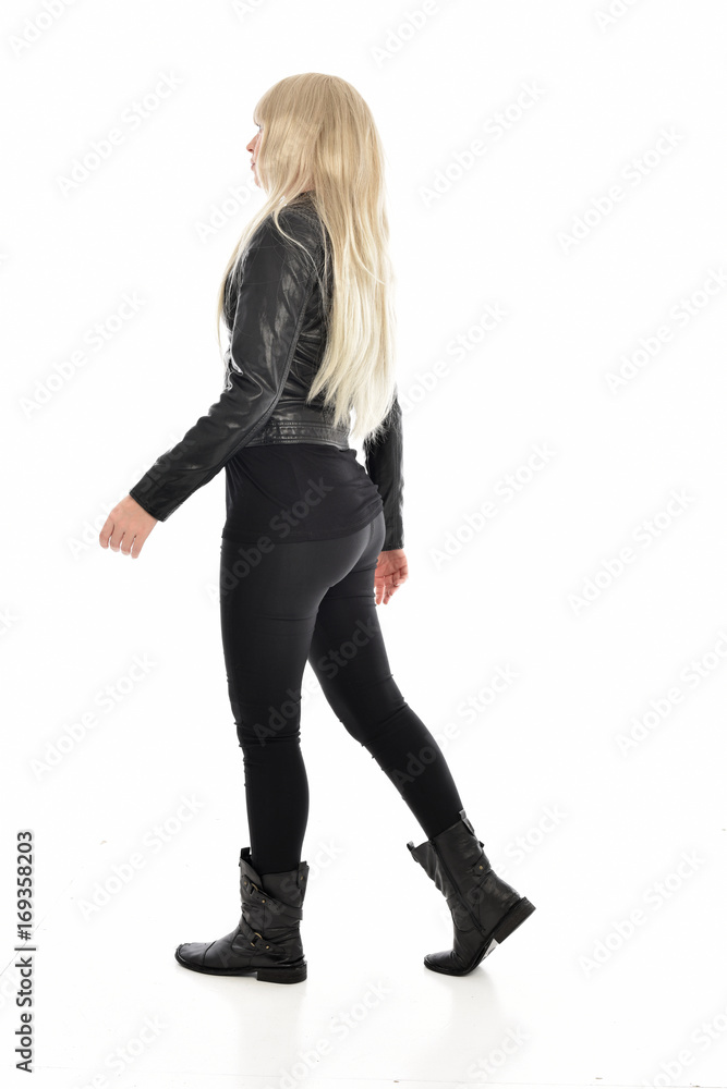 full length portrait of blonde girl wearing black leather outfit, standing pose on white background.