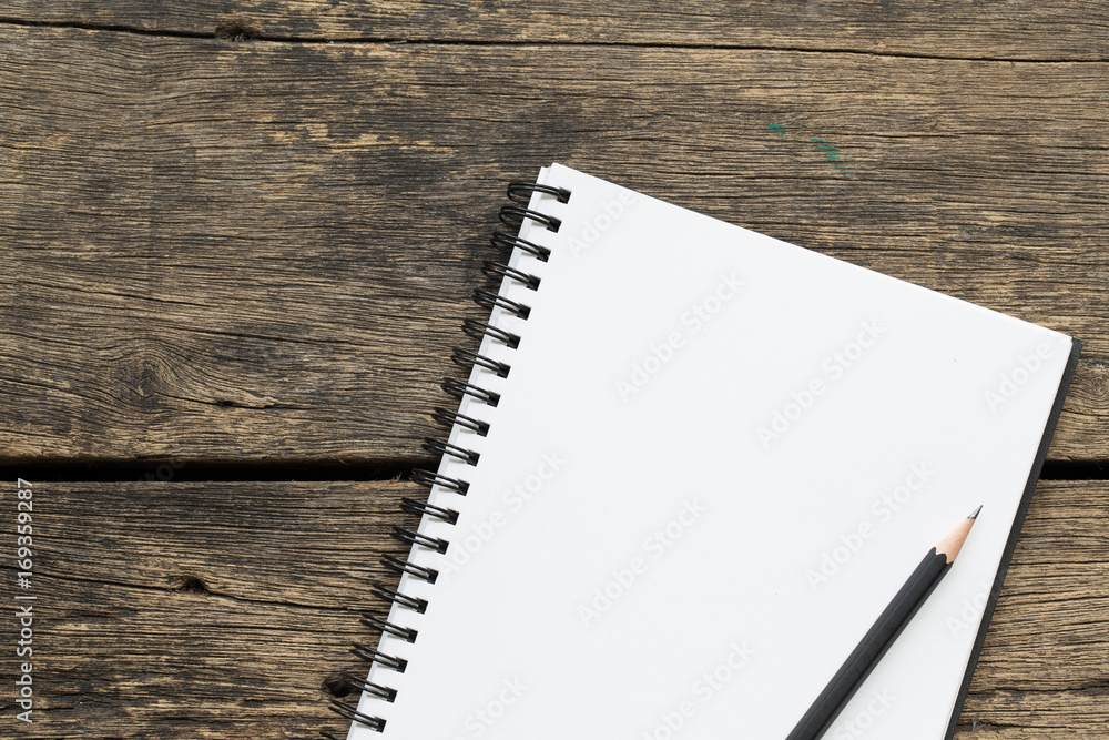 Top view blank notebook paper and pencils on old wooden table Top view blank notebook paper and pencils on old wooden table