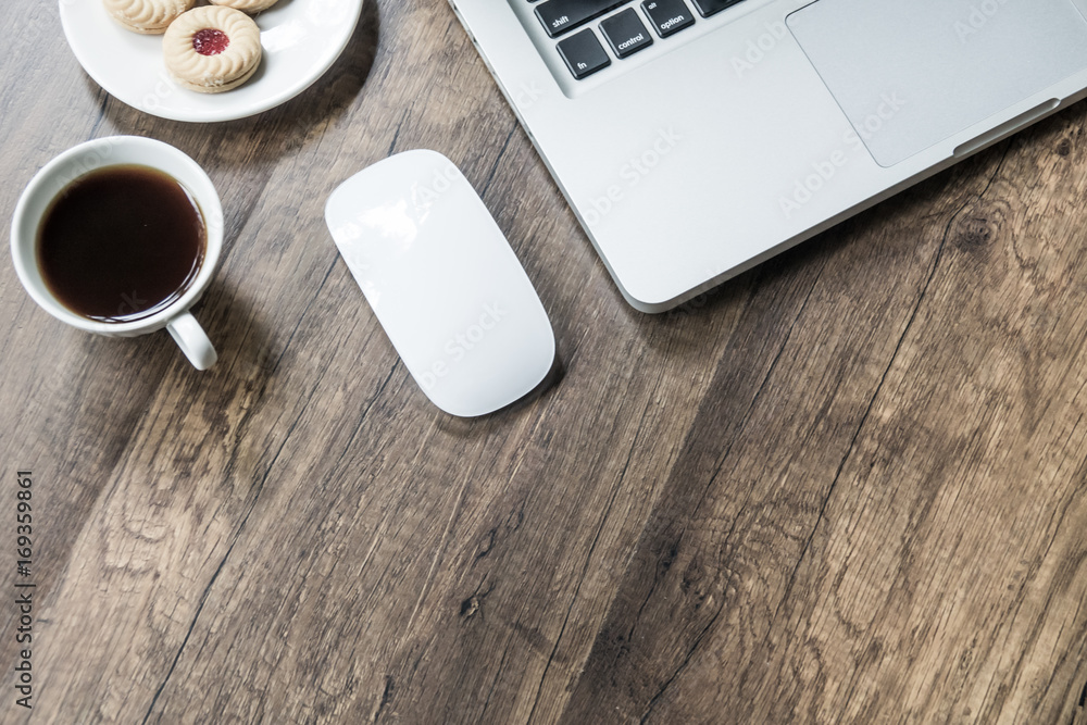 Top view home office table with laptop, coffee and cookie on wooden table. Modern office top view at home. New life style. Concept : business and office.