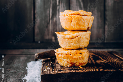 Photos Fresh australian meat pie on the wooden table closeup with copy space, rustic st