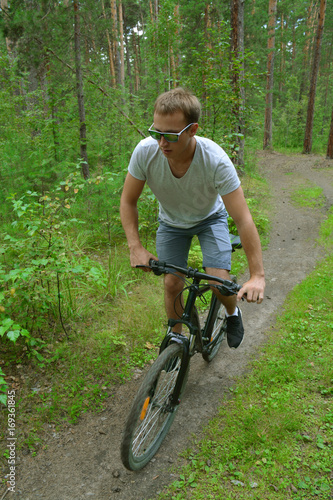 a cyclist on a mountain bike rides through the carriageway along the asphalt road. A healthy lifestyle. A lovable sports hobby