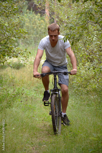 a cyclist on a mountain bike rides through the carriageway along the asphalt road. A healthy lifestyle. A lovable sports hobby