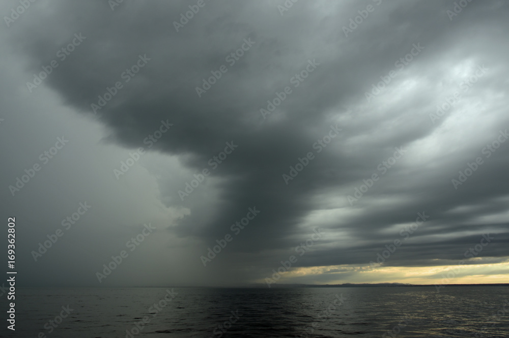 Dunkle Wolken über einem See in der Abenddämmerung