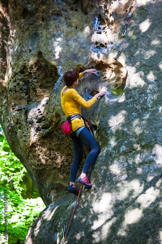 girl climber climbs the rock.