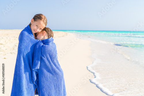 Photography Adorable little girls wrapped in towel at tropical beach after swimming in the s