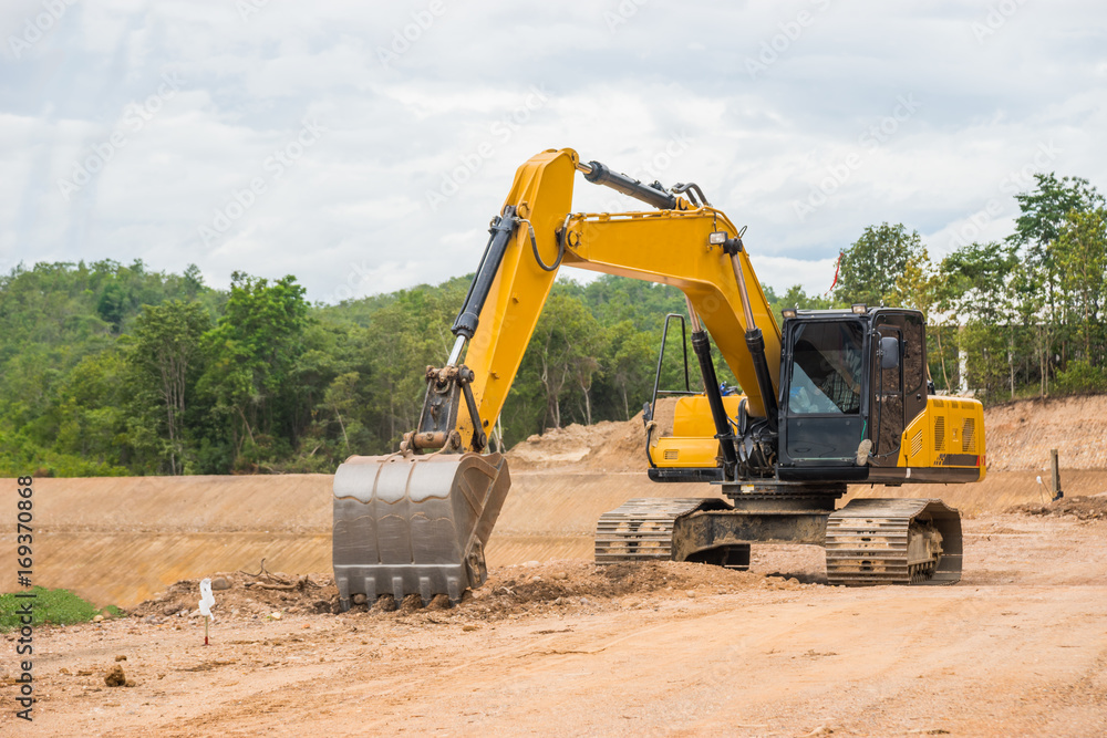 Yellow backhoe excavating soil and sand Yellow backhoe excavating soil and sand
