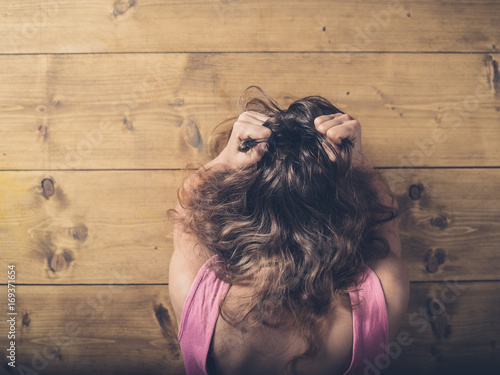 Woman at table pulling her hair in frustration
