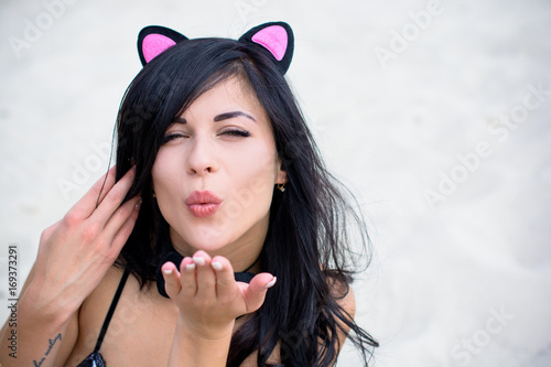 A woman with costume cat's ears and a butterfly around her neck. Playful coquettish girl with a sexual mood ready for role-playing games