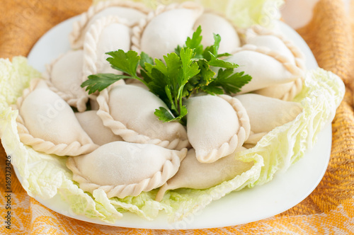 Frozen dumplings on the white plate with green