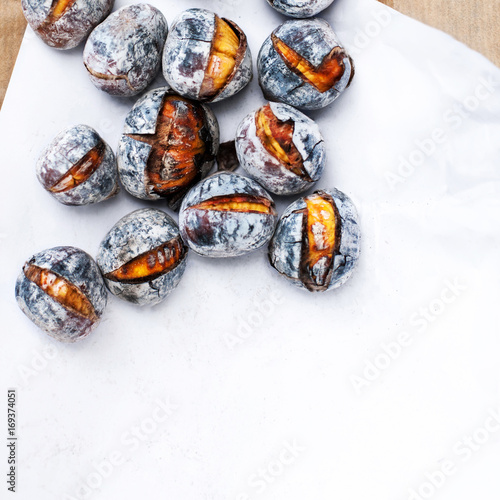 Roasted chestnuts with copy space. Delicious grilled  chestnuts over white background