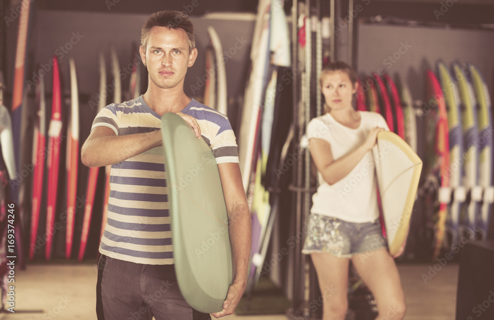 Couple is ready for surfing with board in time summer holidays