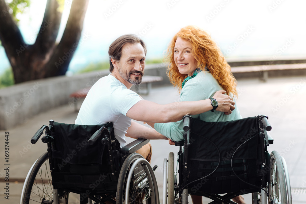 Positive disabled couple resting in the park