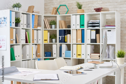 Wallpaper Mural Interior of modern open plan office: documents, notepads and technologies located on desks, shelves with colorful folders, no people Torontodigital.ca
