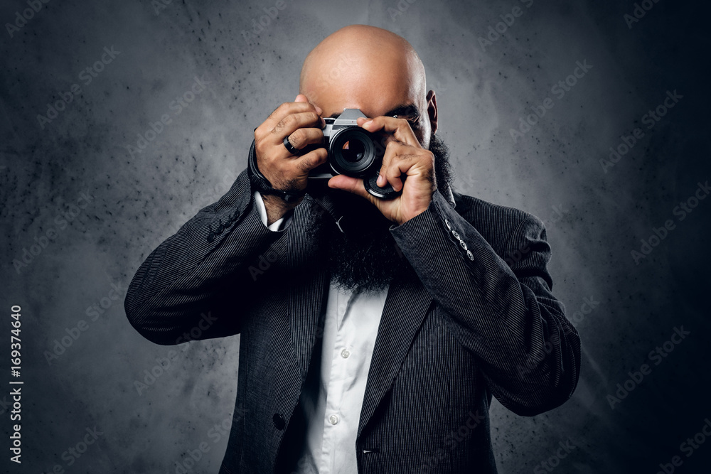 Professional photographer in a suit shooting with a compact DSLR camera. Professional photographer in a suit shooting with a compact DSLR camera.