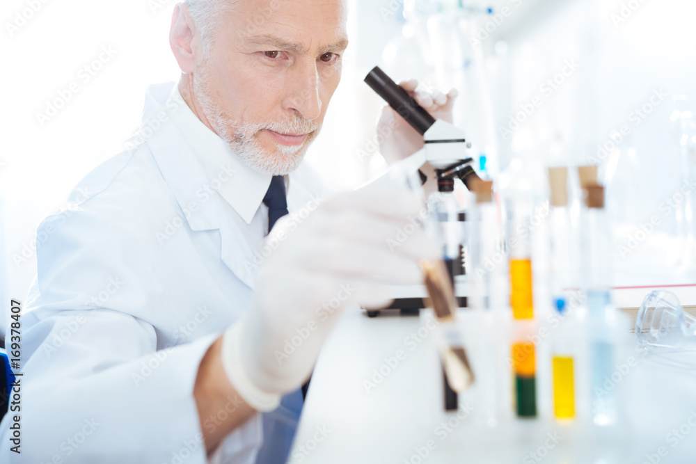 Positive delighted mature scientist doing experiment Positive delighted mature scientist doing experiment