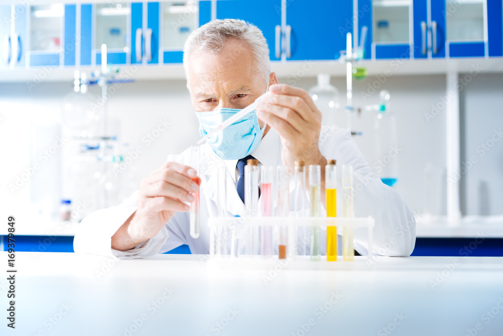 Fototapeta premium Portrait of serious practitioner that mixing reagents