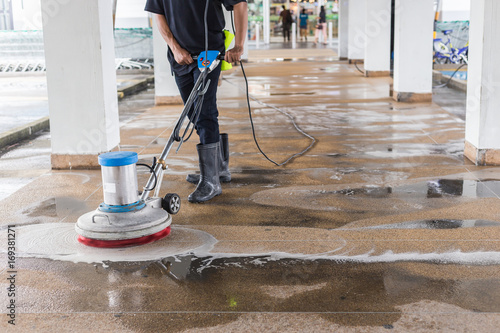 Photos Worker cleaning sand wash exterior walkway using polishing machine and chemical