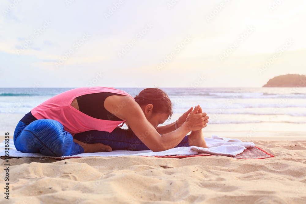 Woman playing Yoga and exercise on the tropical beach in Thailand Woman playing Yoga and exercise on the tropical beach in Thailand
