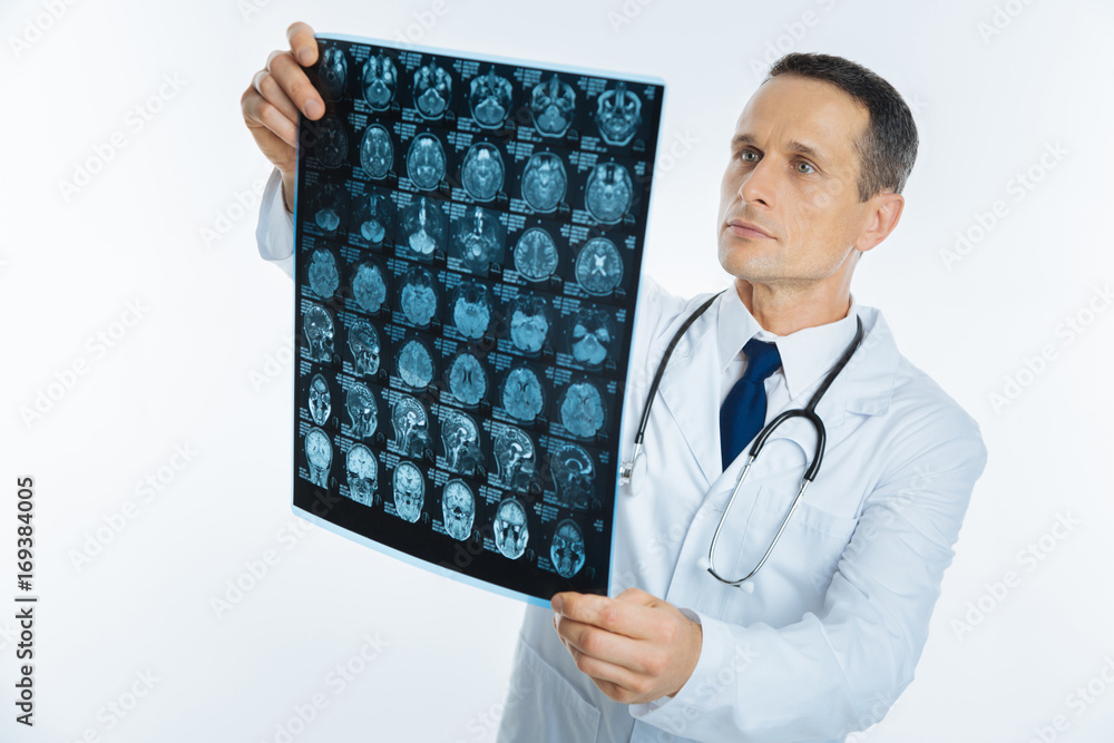 Smart male practitioner examining mri scan image Smart male practitioner examining mri scan image