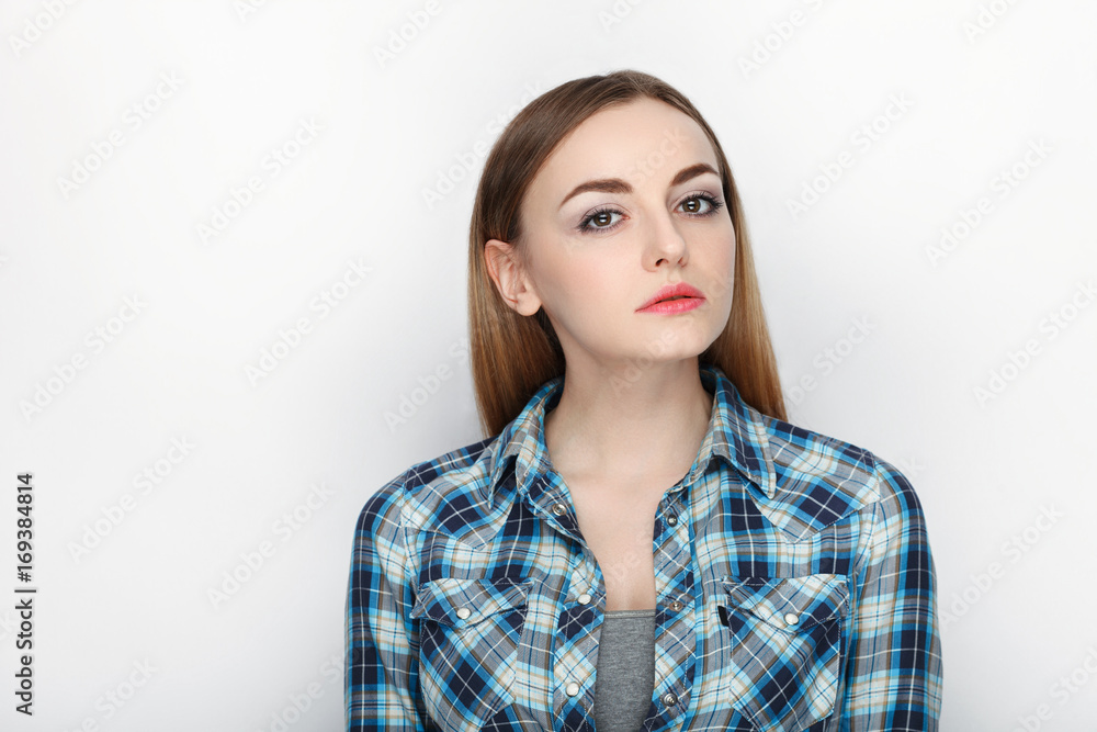 Beauty portrait of young adorable fresh looking blonde woman with hair chaos in blue plaid shirt. Emotion and facial expression concept. Beauty portrait of young adorable fresh looking blonde woman with hair chaos in blue plaid shirt. Emotion and facial expression concept.
