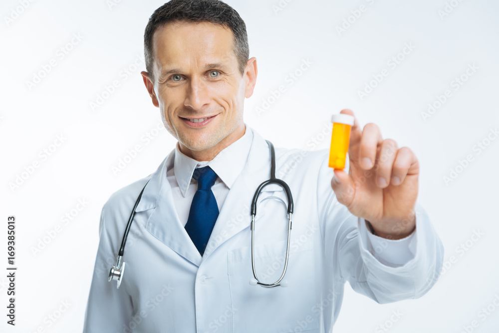 Waist up shot of medical professional holding bottle with medication Waist up shot of medical professional holding bottle with medication