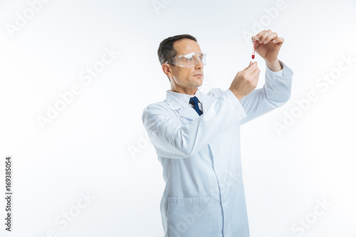 Serious medical worker examining blood sample