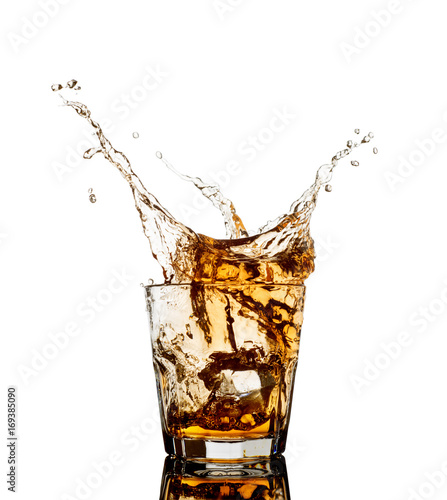 Whiskey splash out of glass isolated on white background