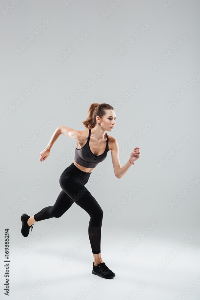 Vertical image of Sport woman running in studio Vertical image of Sport woman running in studio