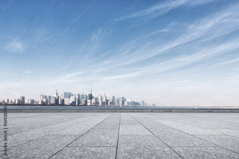 empty marble floor near water with cityscape of modern city