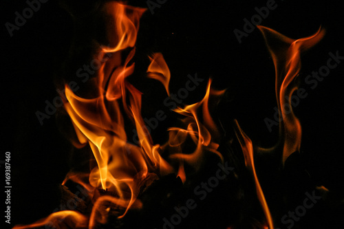 Fire burning inside a brick stove - wood, ash, flames. © dachux21