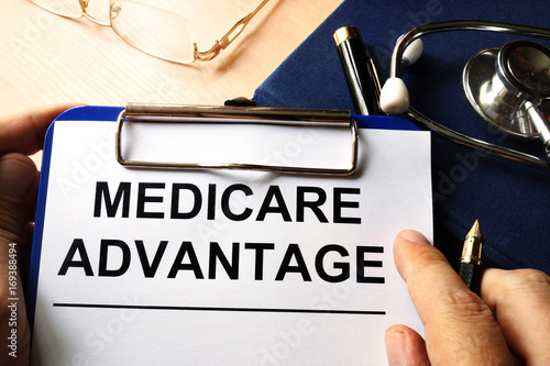 Slika na platnu Medicare advantage in a clipboard. Health care insurance concept.