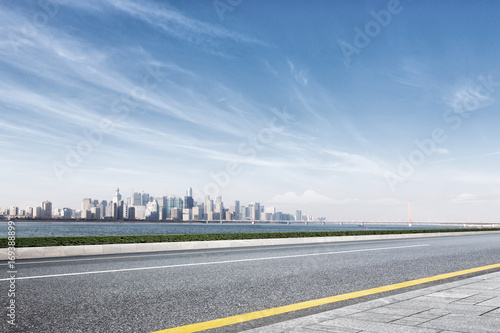 empty road with cityscape of modern city near water