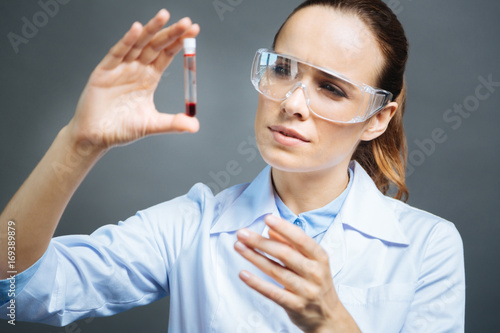 Smart female doctor examining blood sample
