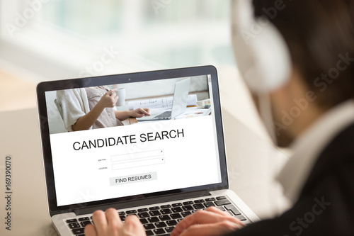 Employer searching candidates for part or full time job on internet web service, headhunter using laptop, looking for experienced professionals, choosing best staff, find resumes, close up rear view