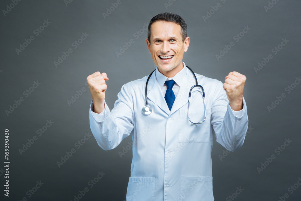 Extremely happy medical professional showing winning sigh Extremely happy medical professional showing winning sigh