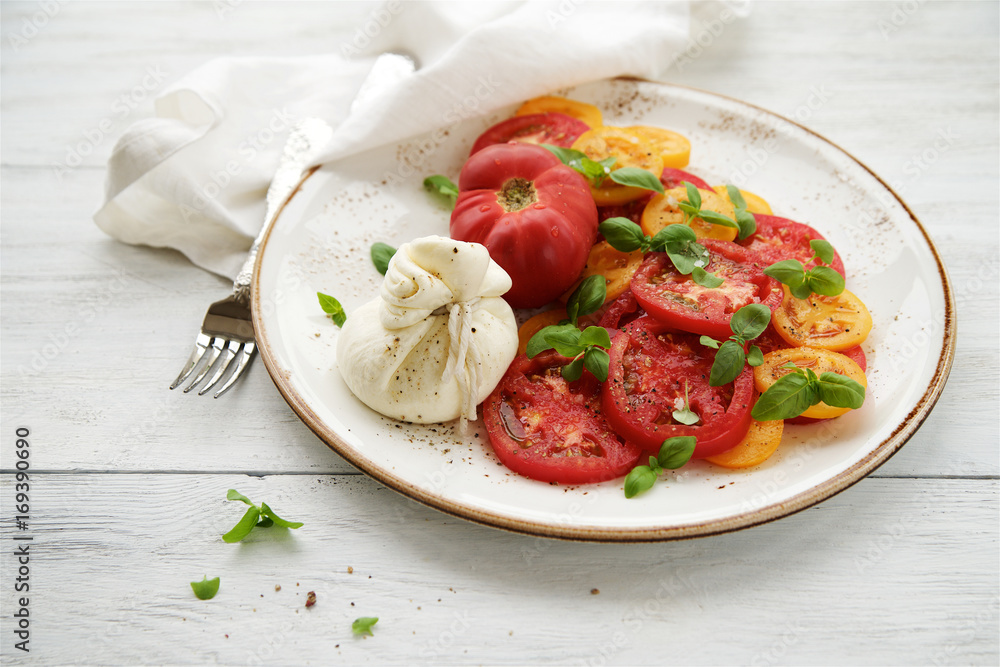 Fresh tomato salad with burrata cheese (mozzarella) and basil. White wooden rustic table
Fresh tomato salad with burrata cheese (mozzarella) and basil. White wooden rustic table