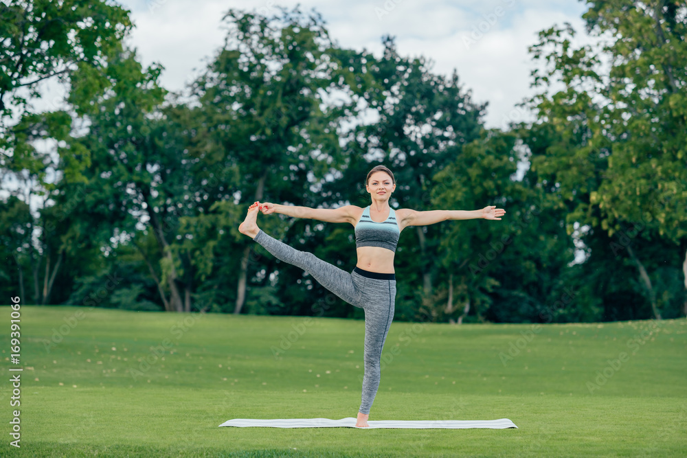 woman practicing yoga in park