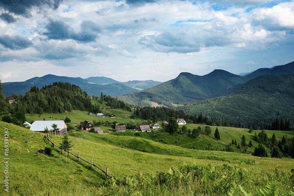 Carpathian mountains summer landscape with cloudy sky and village, natural summer travel background Carpathian mountains summer landscape with cloudy sky and village, natural summer travel background