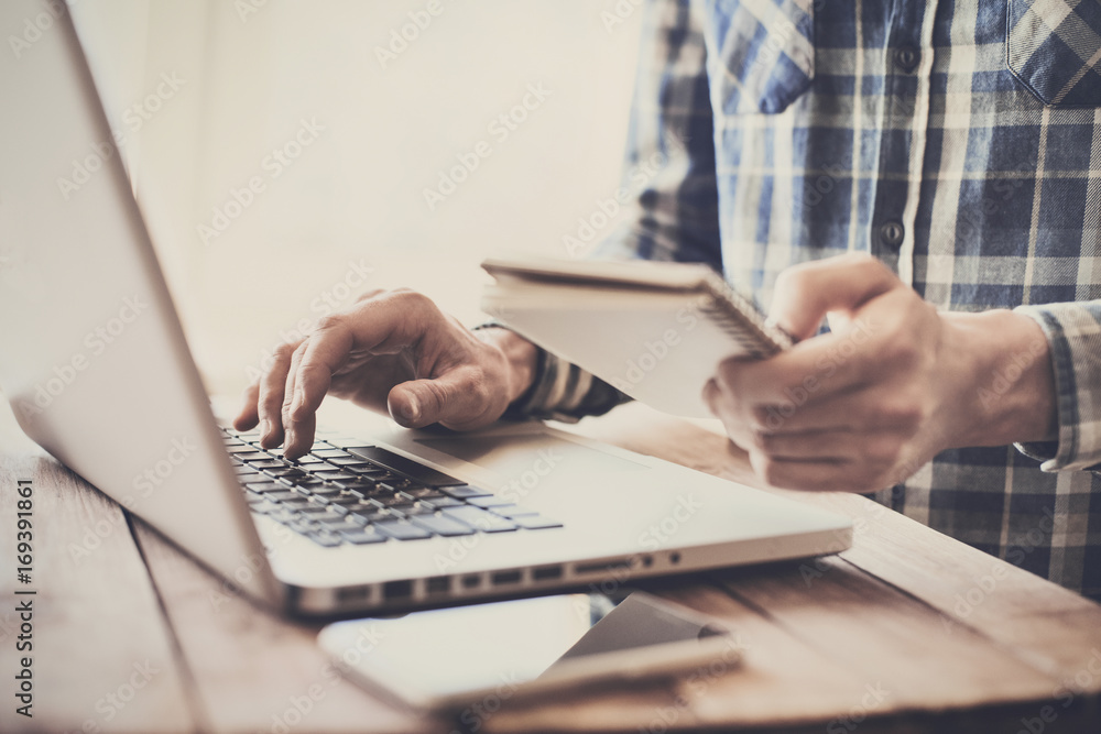 Business man using laptop computer. Male hand typing on laptop keyboard