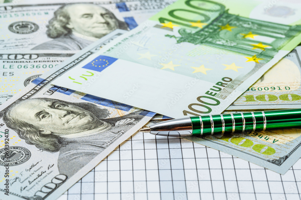 Background with money. American one hundred dollar bills. Euro banknotes. A ballpoint pen next to the bills. Money. Currency. Background with money. American one hundred dollar bills. Euro banknotes. A ballpoint pen next to the bills. Money. Currency.