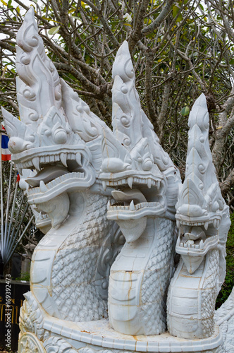 White ceramic naga snake statue on stair of temple photo
