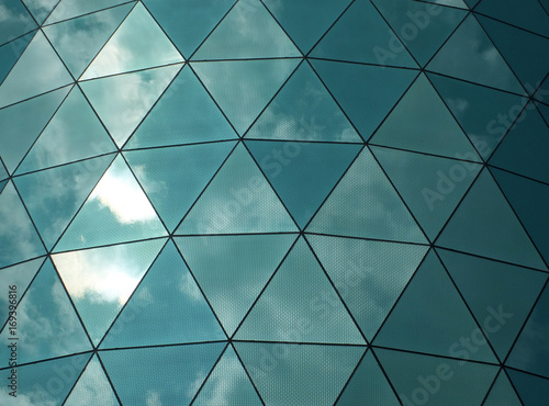 Obraz na plátně angular mirror cladding on a modern structure with reflected sky and clouds