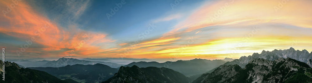 Mountain landscape at sunset in Julian Alps. Amazing view on colorful clouds and layered mountains.