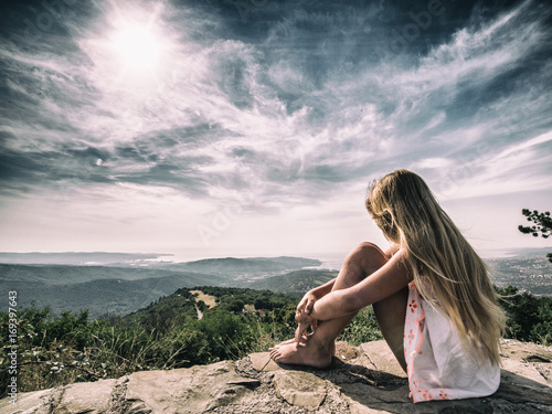 Wallpaper Mural Girl sitting in front of dramatic landscape Torontodigital.ca