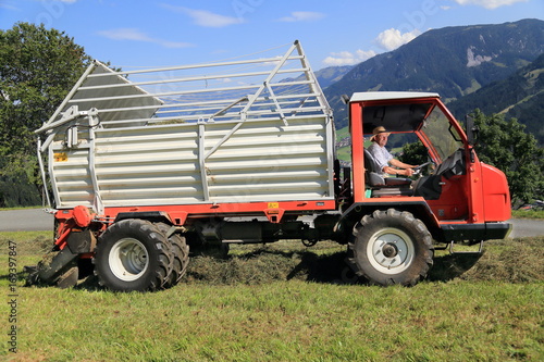 Landwirt Bergbauer Bauer sitzt in einer Erntemaschine Ladewagen