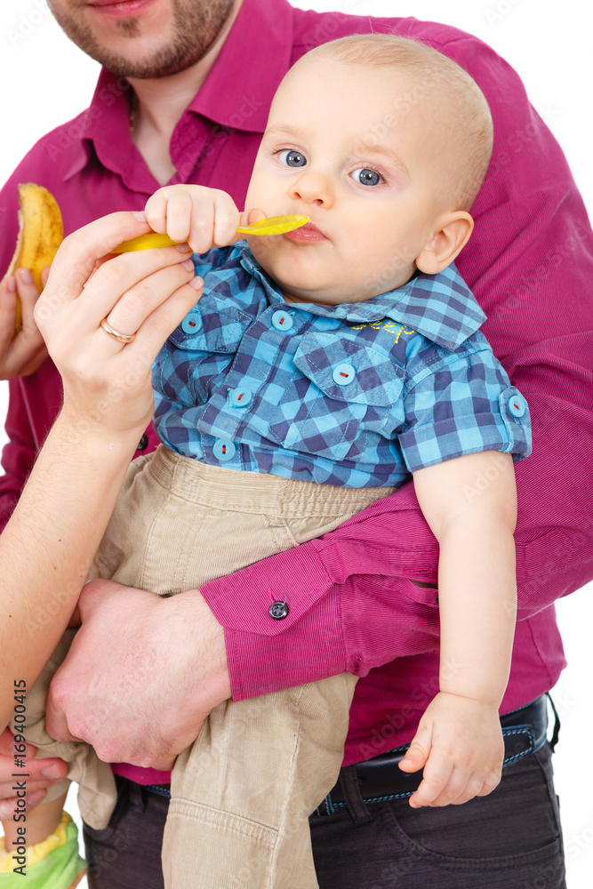 Portrait of a happy baby. Isolated on White Background. Father and Mother feeding baby. Portrait of a happy baby. Isolated on White Background. Father and Mother feeding baby.