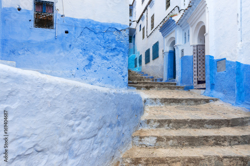 Detail of a narrow street in the mountain town of Chefchaouen with blue buildings, in Morocco  Concept for travel in Morocco © Tiago Fernandez