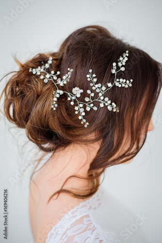 Silver flower wreath put in dark hair of a bride