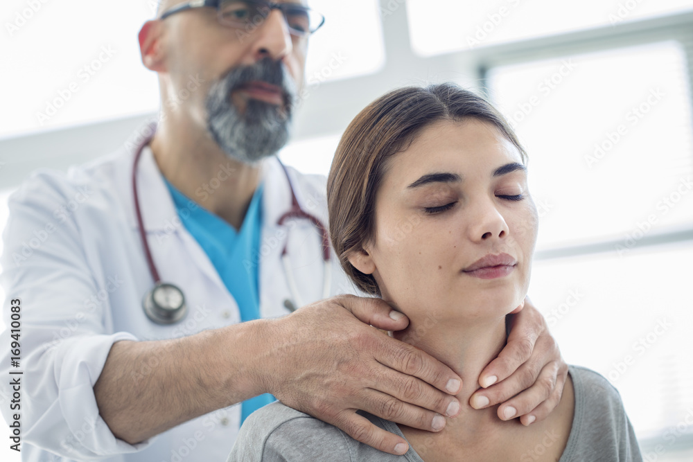 Fototapeta premium Doctor touching throat of patient
