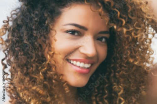 Out of focus portrait of young, lovely woman smiling